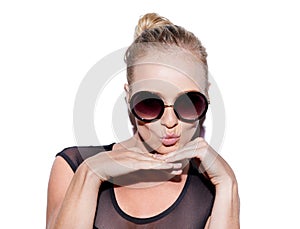 She gets away with it. Portrait of an attractive young woman with sunglasses posing playfully in studio.