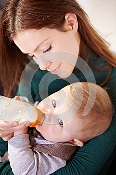 Getting all the nutrients he needs. Pretty young mother bottle-feeding her infant son.