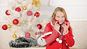 Getting child involved decorating. Girl smiling face hold balls ornaments white interior background. How to decorate