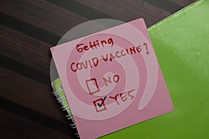 Getting Covid Vaccine write on sticky notes and supported by additional services write on a sticky notes isolated on Wooden Table