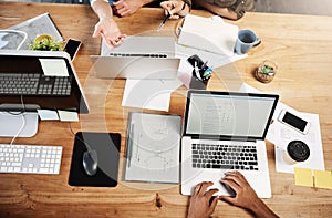 Getting down to business. High angle shot of unrecognizable businesspeople having a meeting in an office.