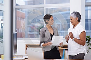 Getting down to the nitty-gritty. two businesswomen discussing paperwork in the office.