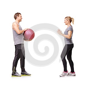 Getting fit and having fun. A man and woman exercising by throwing a medicine ball to each other.