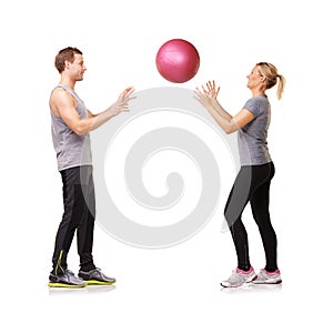 Getting fit together. A man and woman exercising by throwing a medicine ball to each other.