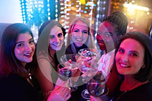 Getting the girls together for a memorable night out. Portrait of a group of young women drinking cocktails at a party.