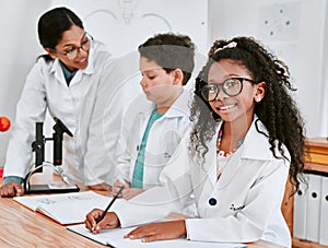 Getting good grades is what she does best. Portrait of an adorable young school girl writing notes in science class with