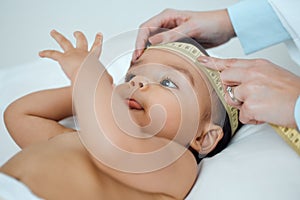 Getting a head-to-toe exam from the doctor. a paediatrician measuring a babys head in a clinic.