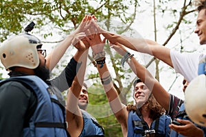 Getting hyped up for the rafting. Cropped shot of a group of young male friends giving each other a high five before