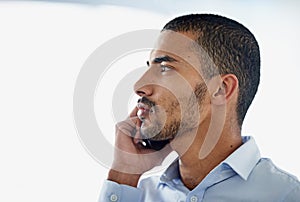 Getting that important call. a handsome young businessman using in cellphone in the office.