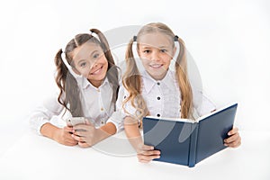 Getting information. Modern data storage instead big paper book. Little girls read paper book and ebook smartphone