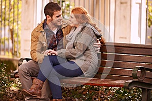 Getting lost in your eyes. a happy young couple sharing an affectionate moment on a park bench.