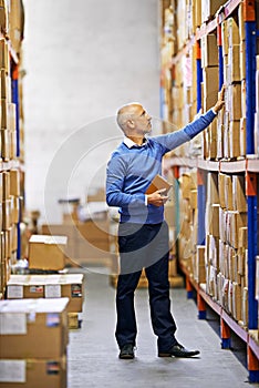 Getting orders ready for shipping. a mature man working inside in a distribution warehouse.