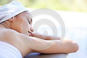 Getting an outdoor massage. an attractive young woman lying on her stomach at a spa.