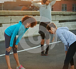 Getting psyched for their run. a group of joggers warming up for an early morning run.