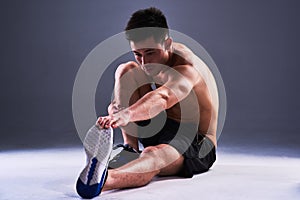 Getting ready. Full length shot of a handsome young man warming up before a workout.