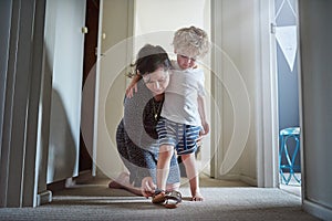 Getting ready for the fun ahead. Shot of a mother helping her son put his shoes on at home.