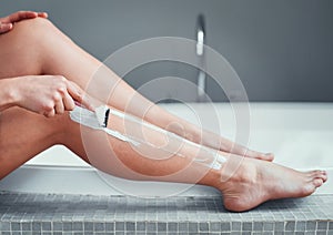 Getting ready for shorts and skirts. Closeup shot of an unrecognizable woman shaving her legs in the bathroom at home.