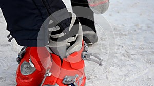 Getting ready for skiing - fastening the boots. Boy wear ski boots. Winter sport. Outdoor.