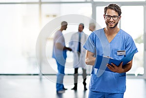 Getting ready to discharge my patient. Portrait of a young doctor reading the contents of a file with his colleagues in