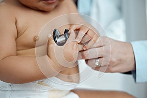 Getting screened to make sure babys health is all good. Closeup shot of a paediatrician using a stethoscope during a