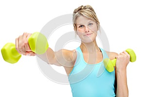 Getting shape for a healthier lifestyle. Sporty young woman lifting dumbbells while isolated on white.