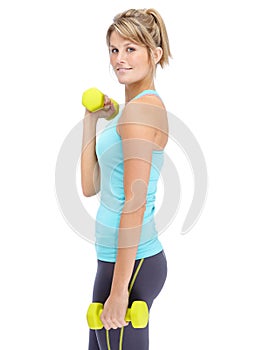 Getting in shape is my goal. Attractive young woman in sportswear lifting dumbbells while isolated on white.