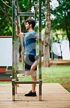 Getting into shape requires strong determination. a sporty young man stretching his legs while exercising outdoors.