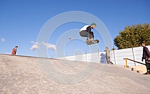 Getting some air. A young man doing tricks on his skateboard at the skate park.