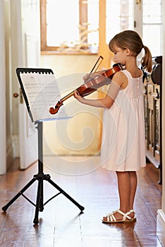 Getting in some violin practive. a young girl playing violin.