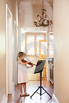 Getting in some violin practive. a young girl playing violin.