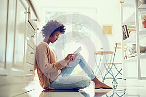 Getting stuck into that ebook shes been wanting to read. Shot of a young woman using a digital tablet at home.