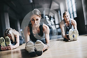 Getting their muscles ready. Full length shot of three attractive and athletic women stretching before their workout in