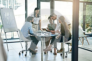 Getting their plans together. a group of colleagues working together in an office.