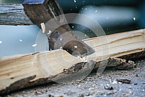 Getting wood for fire: Sharp axe cutting wood on a block