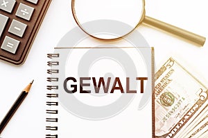 GEWALT on notepad with calculator, magnifier, money and pencil on the office desk photo