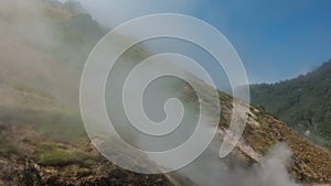 A geyser erupts on the mountainside.