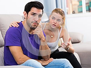 Ggirl comforting upset boyfriend on sofa