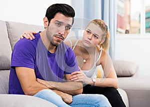 Ggirl comforting upset boyfriend on sofa