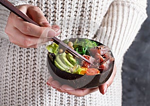 GGirl eating hawaiian tuna poke salad in the bowl