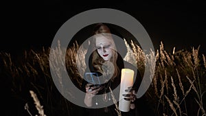 Ggirl in the image of witch uses mobile phone. Halloween image.