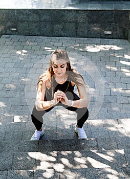 Ggirl wearing sporty clothes, doing squat exercise