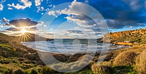 Ghajn Tuffeha, Malta - Panoramic view of Ghajn Tuffieha beach at sunset on a lovely summer day with beautiful sky photo