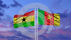 Ghana and Cameroon two flags on flagpoles and blue sky.