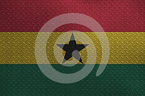 Ghana flag depicted in paint colors on old brushed metal plate or wall closeup. Textured banner on rough background