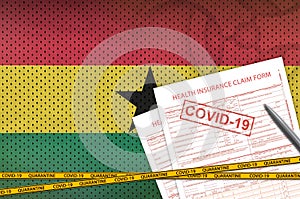 Ghana flag and Health insurance claim form with covid-19 stamp. Coronavirus or 2019-nCov virus concept