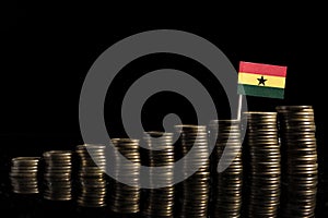 Ghanaian flag with lot of coins isolated on black