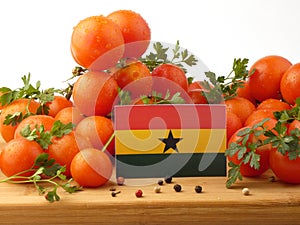 Ghanaian flag on a wooden panel with tomatoes isolated on a whit