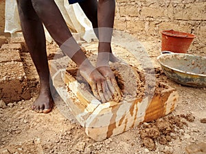 Ghanaian worker forming mud brick