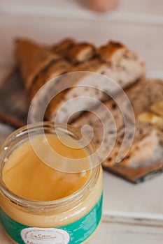 Ghee butter in glass jar and sliced bread on table. Healthy eating, breakfast