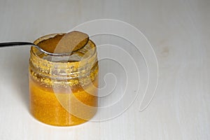 Ghee or clarified butter in a jar with steel spoon on wooden background. photo